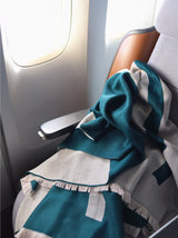 Luxuriöse schöne und besondere Reisedecke und Schal in petrol beige aus Merino Wolle als Reise Accessoire für Business Class und gehört ins Handgepäck bei Flugreisen