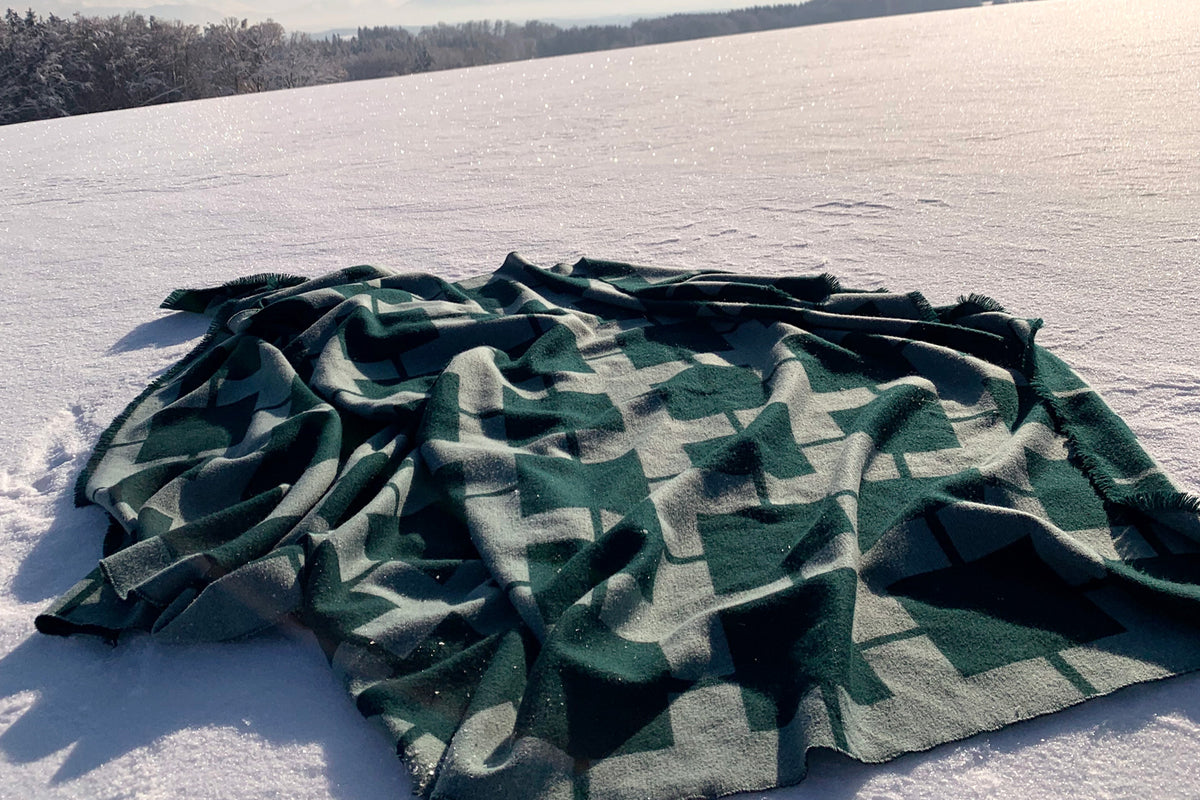 Wärmende hochwertige Wolldecke in Grün Petrol mit Muster aus Merino Wolle als Wohndecke und Plaid fürs Wohnzimmer an kalten Tagen oder für Garten und Terrasse