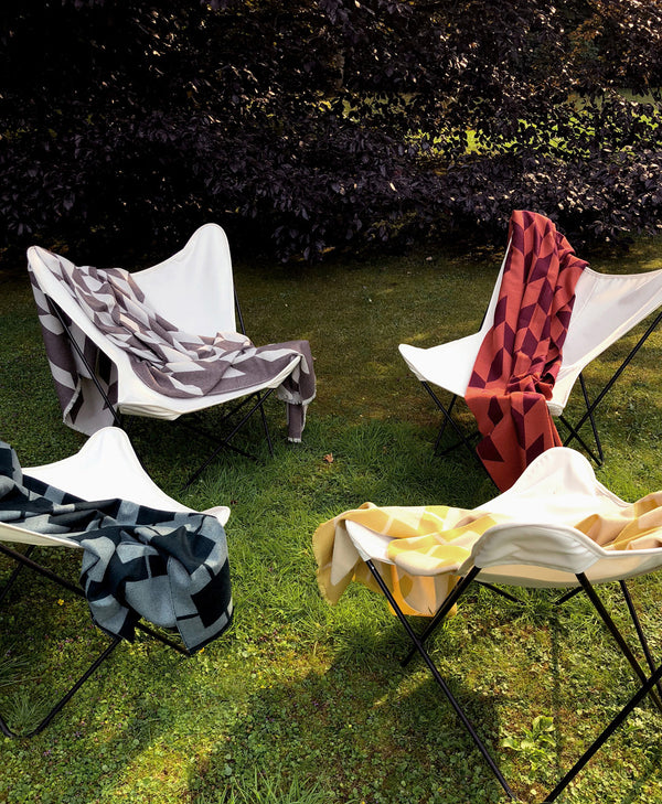 Unsere Favoriten Wolldecken aus Extra Fine Merino über Butterfly Chair im Garten Sommer