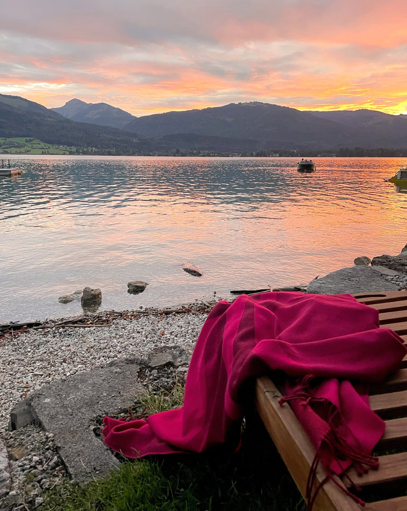 Reisedecke in Pink aus Merino auf Gartenliege am Ufer des Wolfgangsee und bei Sonnenuntergang auf dem Boot und zum einkuscheln