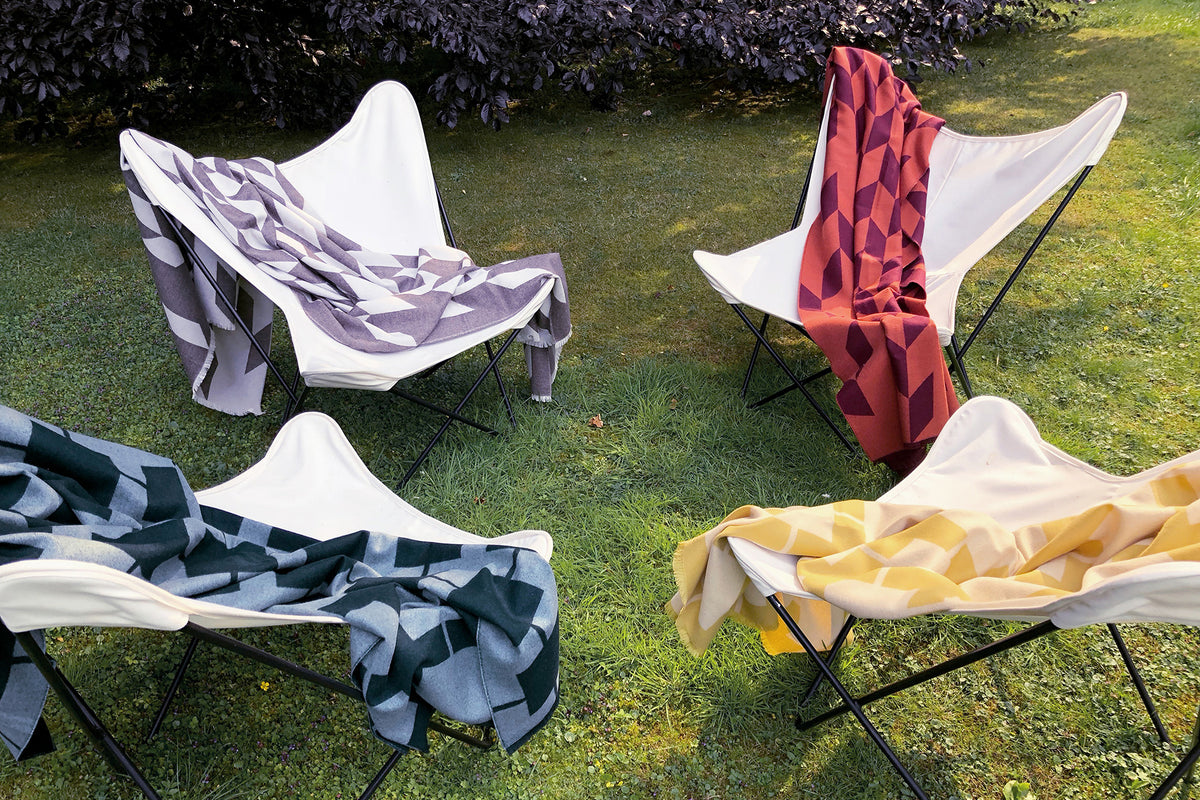 Hochwertige Wolldecken aus Merino für lange Sommernächte im Garten über schönen Gartenmöbeln