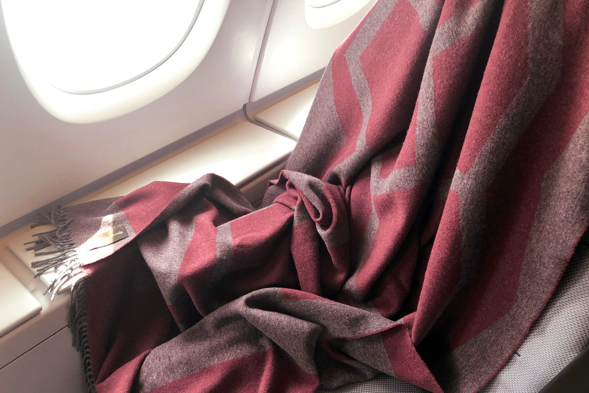 Weiche hochwertige Reisedecke in Aubergine und Grau aus Yak und Merino Wolle als Begleiter im Flugzeug zum Einkuscheln und Zudecken bei Langstreckenflug und Nachtflug