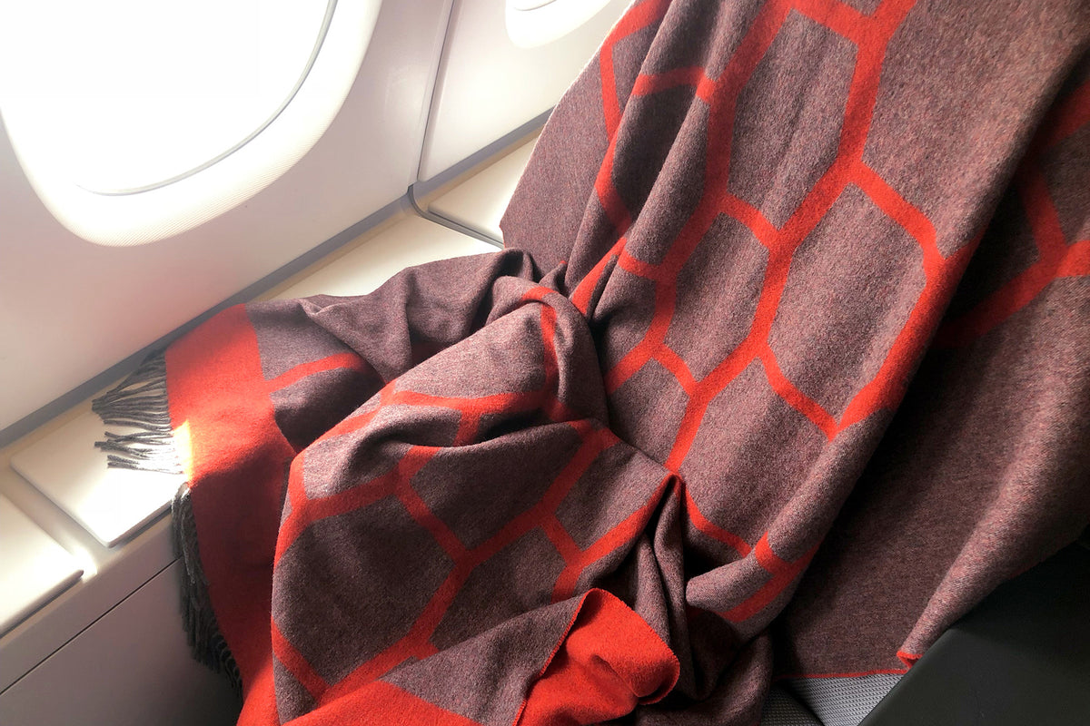 Weiche hochwertige Reisedecke aus Yak und Merino als Begleiter im Flugzeug zum Einkuscheln und Zudecken bei Langstreckenflug und Nachtflug