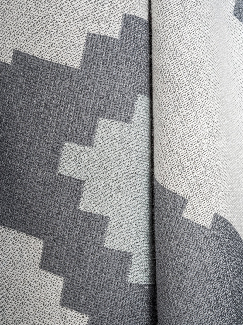 Wolldecke mit buntem grafischen grau Muster aus Merino und Mohair gestrickt als zeitloses Interieur-Accessoire für Stil zu Hause in luxuriösem Design und Nachhaltigkeit und das perfekte Geschenk für Wohnzimmer und Stil Liebhaber