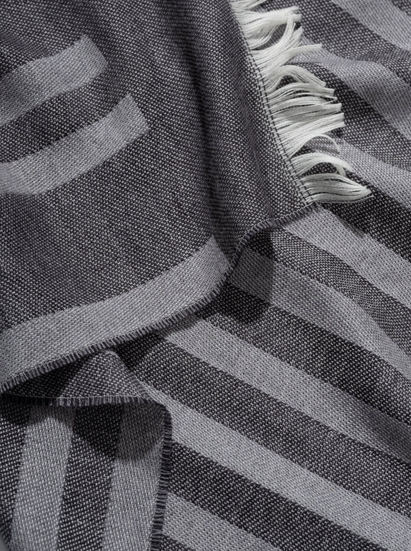 Schal Detail aus Merinowolle gewebt in dunkelgrau und weich als Accessoire in Streifen Design mit Nachhaltigkeit als das perfekte Geschenk für Fashion Styling