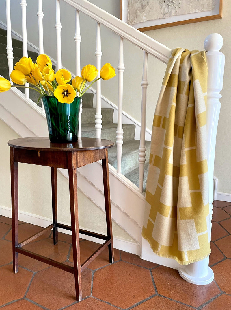 Wolldecke in gelb weiss Muster aus extra feinem Merino gewebt als zeitloses Plaid Interieur Accessoire für Zuhause in luxuriösem Design und Nachhaltigkeit und das perfekte Geschenk für jedes Sofa und vor Kamin im Chalet