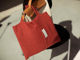 Travel blanket and Hermès vintage handbag in red gray woven from Merino and good as a travel accessory with pillowcase and handle for hand luggage in a luxurious design with sustainability made as the perfect gift for cruises and city trips
