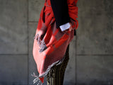 Travel blanket in red gray woven from Merino and Yak and practical as travel fashion for airplanes or private jets in a luxurious design with sustainability and as the perfect gift for weekend trips or mountain holidays and in gas crises when saving energy and heating in the cold winter