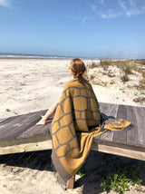 Reisedecke und Schal in gelb grauem Muster aus Merino und Yak Wolle gewebt und ideal als Keypiece für Wochenenden am Strand mit Oldtimer oder in Bergen in luxuriösem Design mit Nachhaltigkeit und das perfekte Geschenk für den Urlaub und in Gaskrise bei Energie Sparen und Heizen im kalten Winter